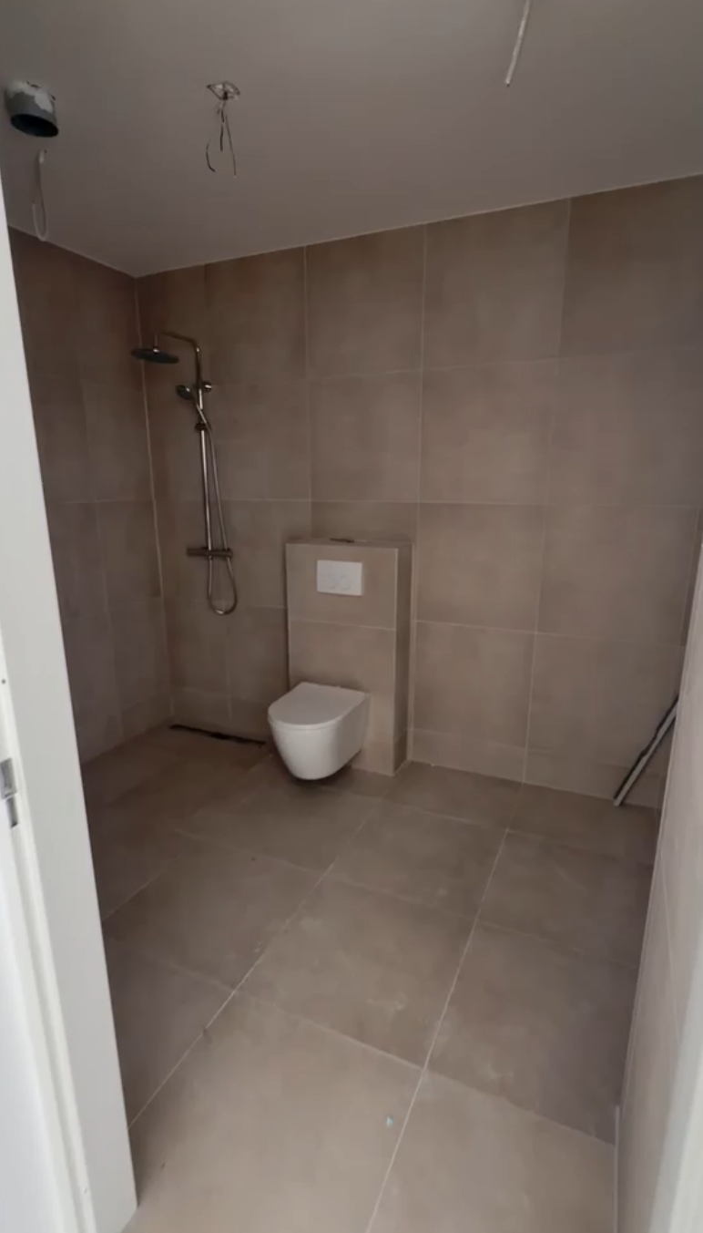 Afgewerkte badkamer met inloopdouche en toilet in een van de zes appartementen in Groenlo