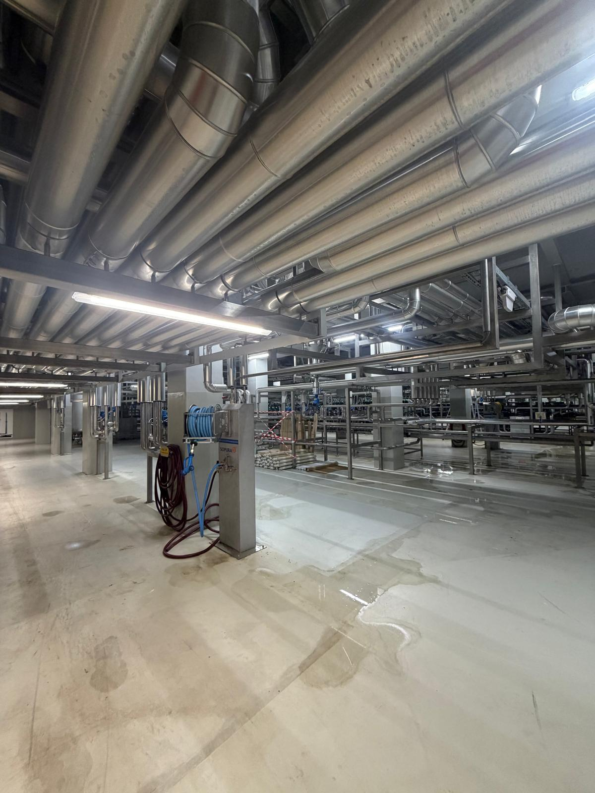 Leidingwerk en aansluitpunten in de fabriekshal van Grolsch