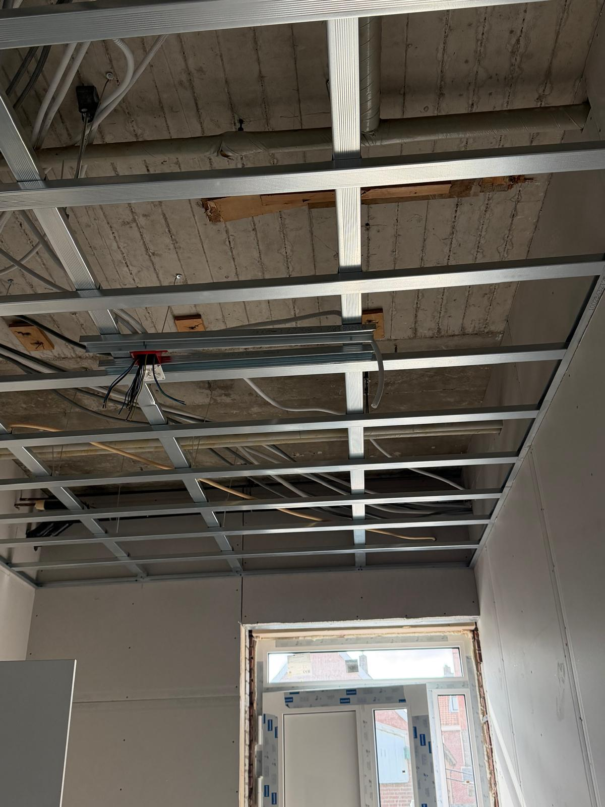 Leidingwerk en centraaldozen in het plafondframe tijdens de verbouwing in Groenlo