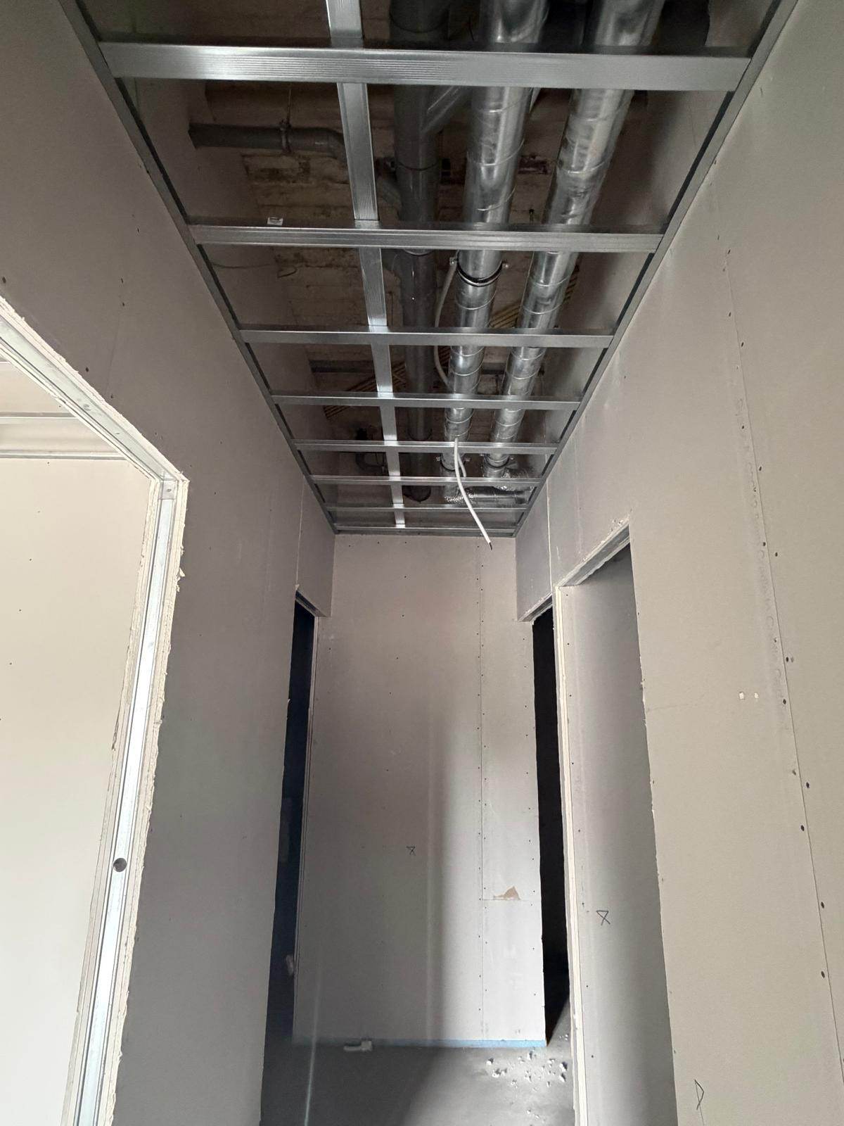 Plafondframe met kanaalwerk en bedrading in de gang van het appartementencomplex in Groenlo